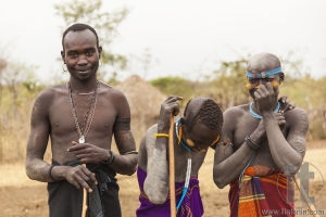 Boys and a man from Mursi tribe with spears in Mirobey village.
