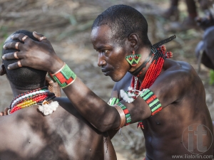 Hamar men paint each other's face in a preparation to a bull jumping ceremony.