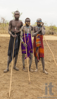 Boys and a man from Mursi tribe with spears in Mirobey village.