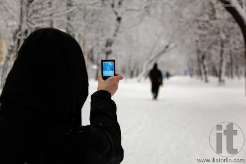 Woman taking picture with digital camera in one of Moscow boulevards. Russia.