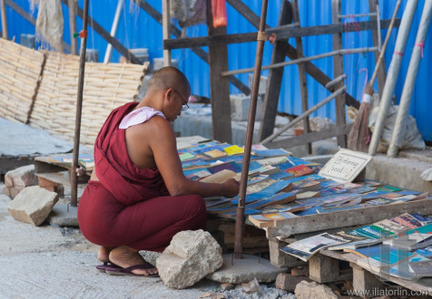 Buddhist monk choosing book on street market. Yangon. Myanmar.