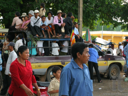 Overcrowded bus, with locals sitting even on the roof, is about to leave bus station. Phnom Penh. Cambodia.
