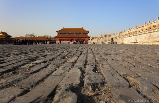 Ancient bricks of courtyard with Hongyi Pavilion and the marble terrace of Three Great Halls Palace on the background. Forbidden City. Beijing. China.