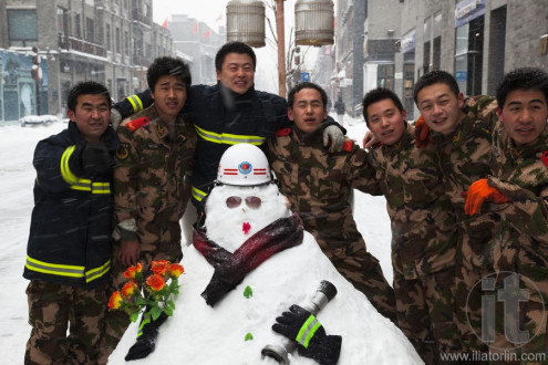 The biggest snowstorms in 60 years. Fire crew making snowmen in Qianmen Beijing, China.