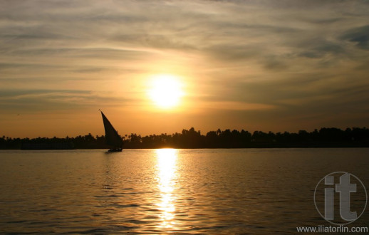 Felucca sailing on the River Nile against sunset.