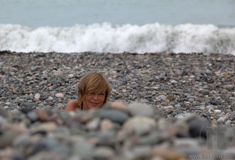 Smiling lady on pebbles beach. Batumi. Georgia.