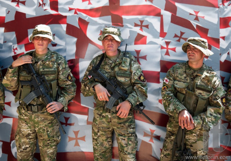 Soldiers posing in front of Georgian flag. Tbilisi. Georgia.