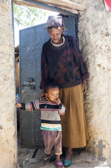 Grandmother with grandchild posing in the entrance of their house in ancient walled city of Jugol, that daily life is almost unchanged in more than four hundred years. Harar. Ethiopia.