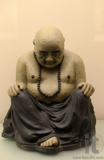 Sitting bowed Buddha. Antique sculpture. Hong kong.