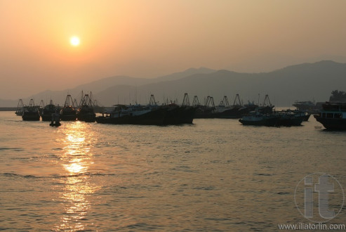 Sunset. Fishing boats anchored in Cheung Chau harbour. Hong Kong.