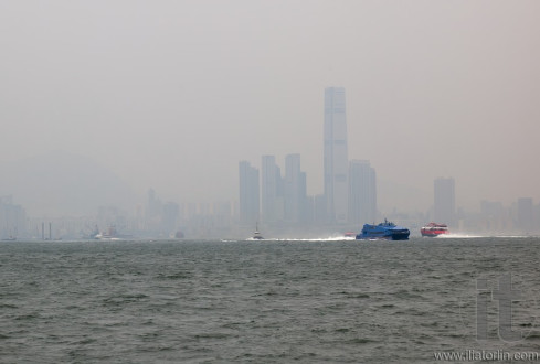 View of skyscrapers with boats in the foreground. Hong Kong.