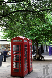 Red phone booths on small pedestrian street in central London. UK.