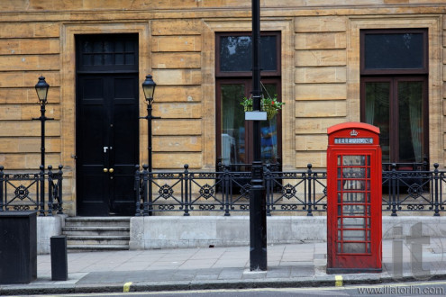Red phone booths on street of central London. UK.