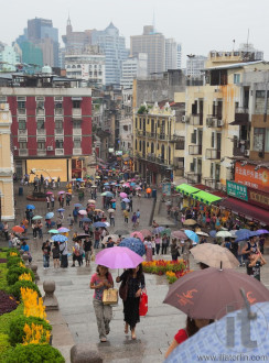 People under colourful umbrellas. Rainy day. Macau. China.