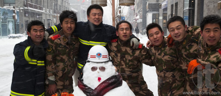 The biggest snowstorm in 60 years. Fire crew making snowmen in Qianmen Dajie. Beijing, China.