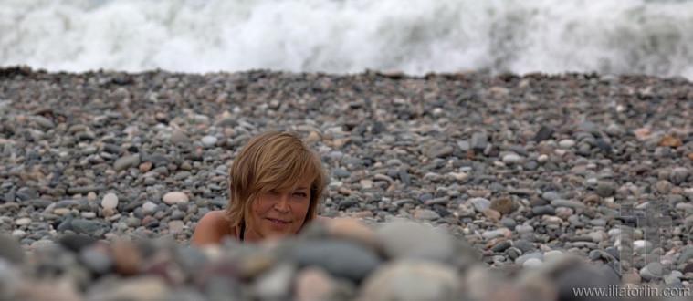 Smiling lady on pebbles beach. Batumi. Georgia.