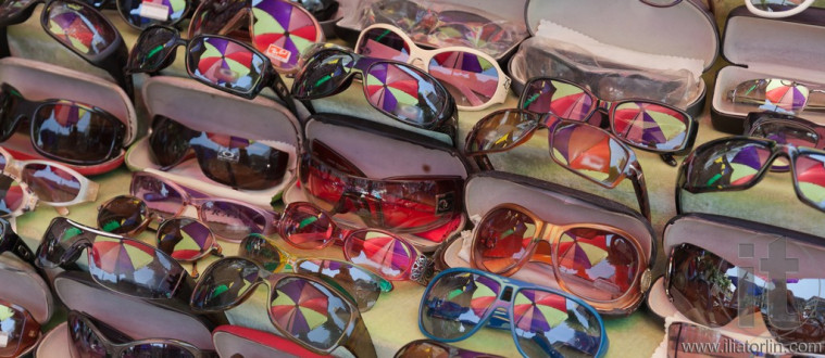 Colourful umbrella reflected in sunglasses at street market. Yangon. Myanmar.